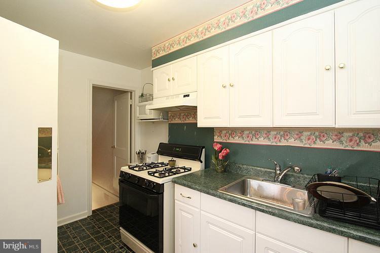 11942 Bluhill Road Silver Spring, MD 20902 - Photo 11 of 30 a kitchen with a sink and a stove top oven