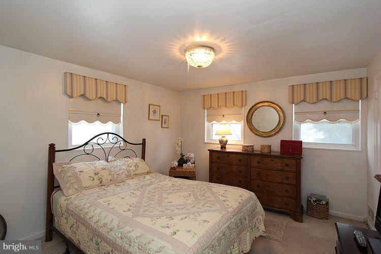11942 Bluhill Road Silver Spring, MD 20902 - Photo 20 of 30 a bedroom with a bed and wooden floor
