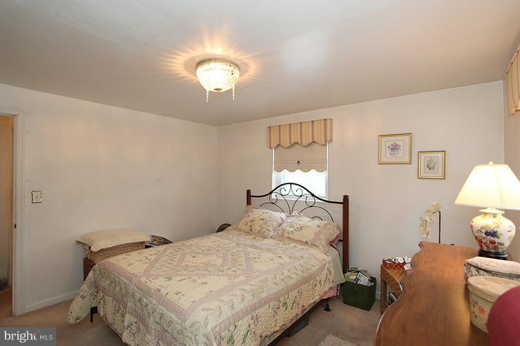 11942 Bluhill Road Silver Spring, MD 20902 - Photo 3 of 30 a bedroom with a bed and a chandelier