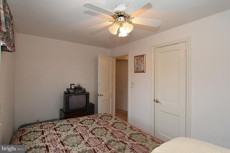 11942 Bluhill Road Silver Spring, MD 20902 - Photo 27 of 30 a bedroom with a bed and a chandelier