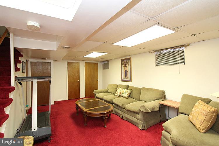 11942 Bluhill Road Silver Spring, MD 20902 - Photo 8 of 30 a living room with furniture a large window and gym equipment