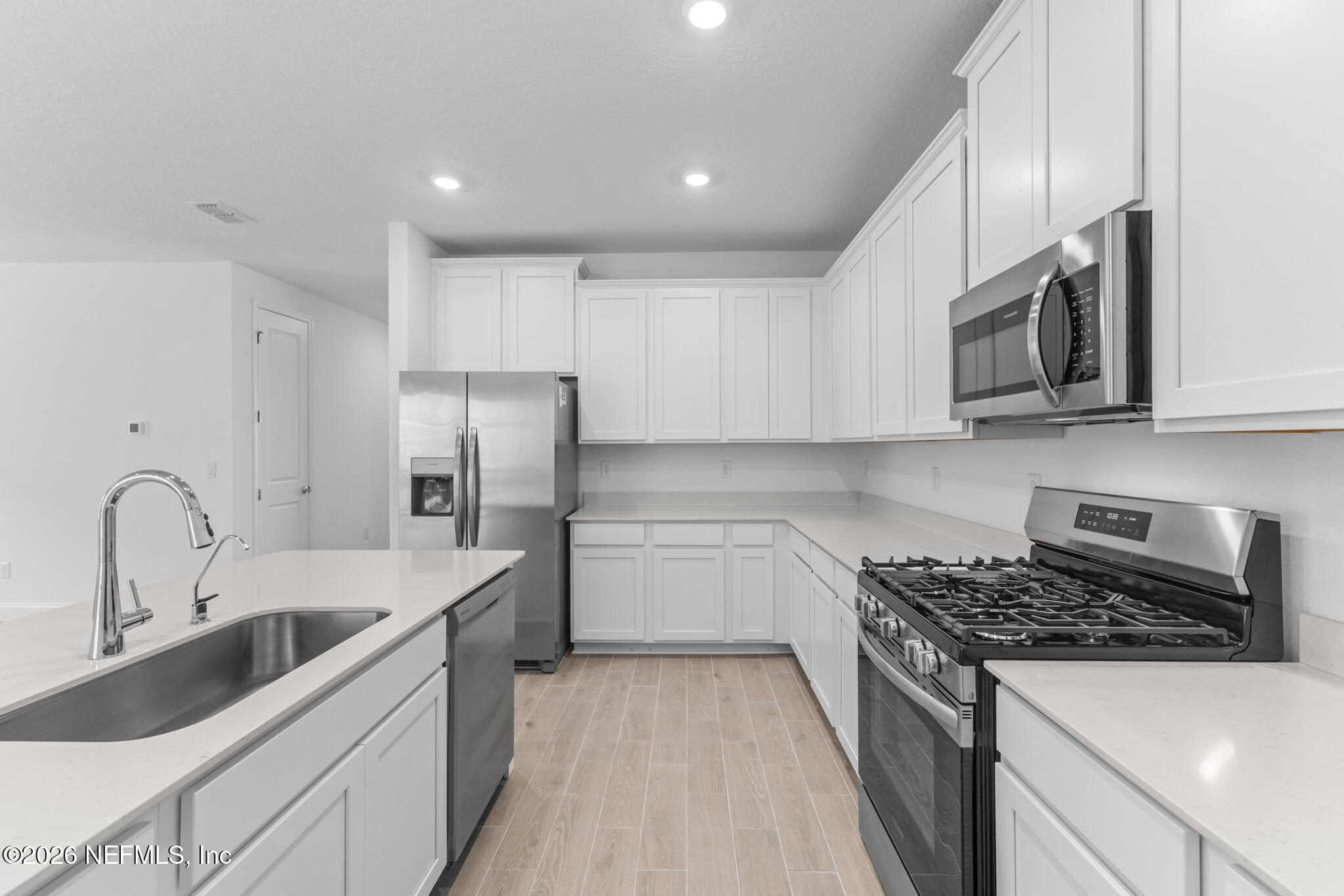 299 Pentwater Road St. Augustine, FL 32092 - Photo 17 of 25 a kitchen with stainless steel appliances granite countertop a sink stove a refrigerator and cabinets with wooden floor