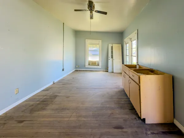 a view of a kitchen with dishwasher and white cabinets with wooden floor