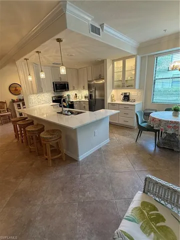 a kitchen with a sink dining table and chairs