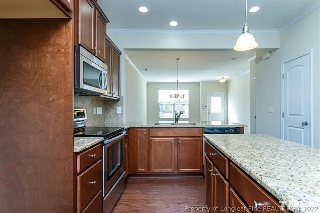 a kitchen with kitchen island granite countertop a sink and stove