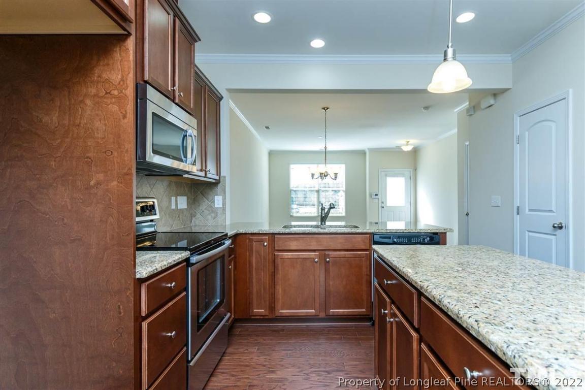 110 Mt Evans Drive Durham, NC 27705 - Photo 11 of 27 a kitchen with kitchen island granite countertop a sink and stove