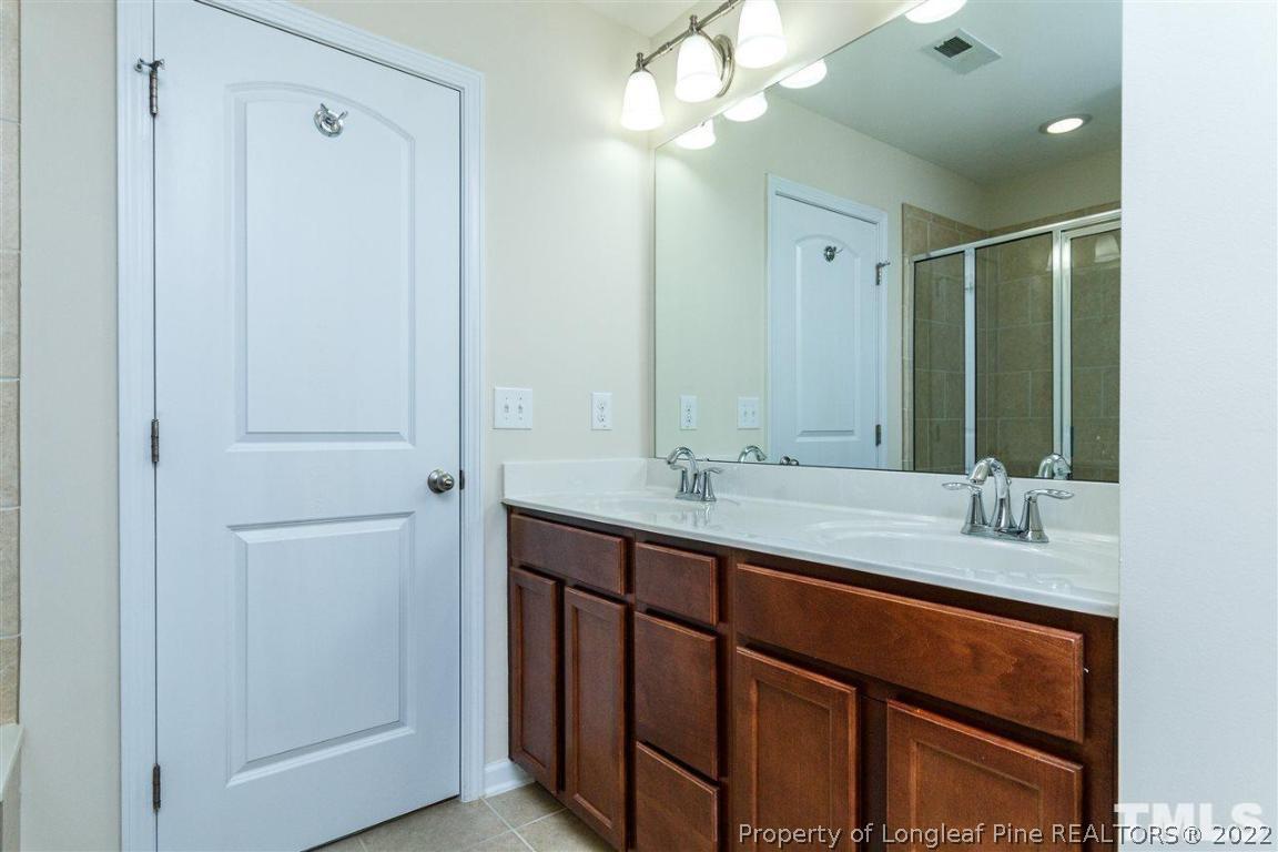 110 Mt Evans Drive Durham, NC 27705 - Photo 17 of 27 a bathroom with a double vanity sink and a mirror