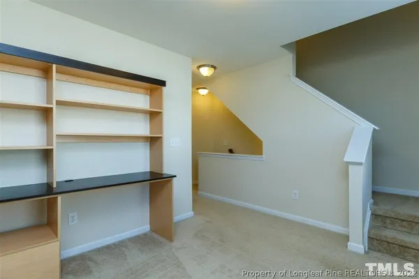 a view of an empty room with cabinet and a window