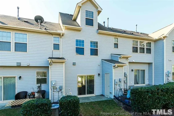 a view of a house with brick walls and a yard with plants
