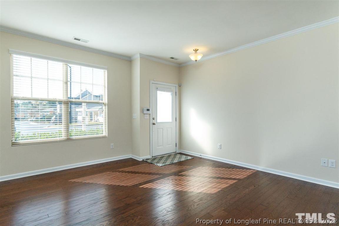 110 Mt Evans Drive Durham, NC 27705 - Photo 4 of 27 an empty room with wooden floor and windows