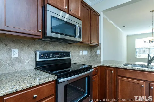 a kitchen with granite countertop a stove top oven microwave and cabinets