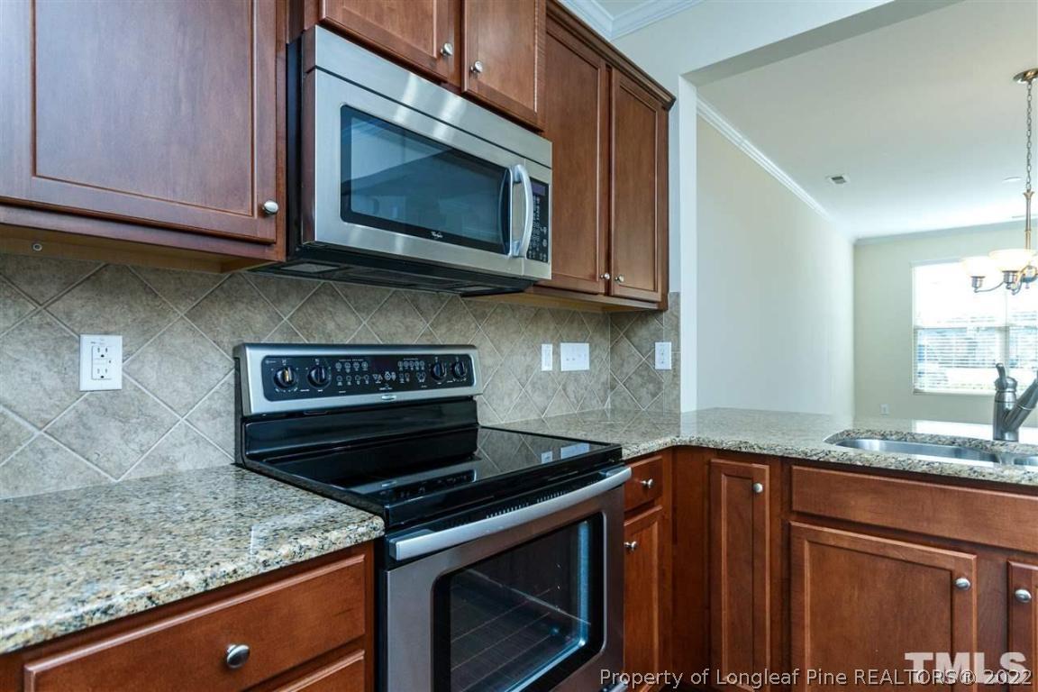 110 Mt Evans Drive Durham, NC 27705 - Photo 10 of 27 a kitchen with granite countertop a stove top oven microwave and cabinets