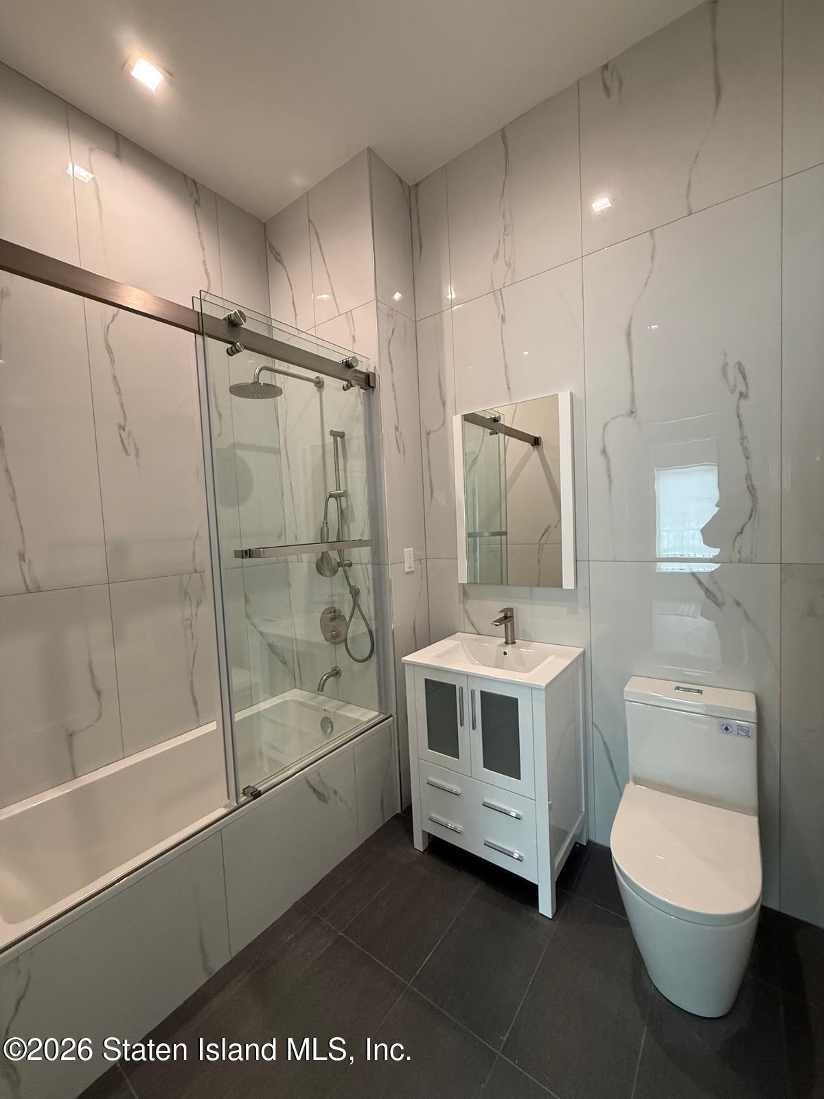 1239 Forest Hill Road, Unit 21 Staten Island, NY 10314 - Photo 15 of 15 a bathroom with a sink a toilet and shower