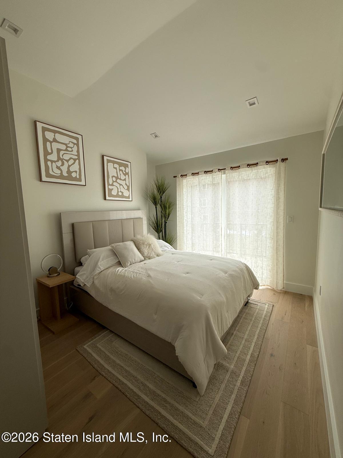 1239 Forest Hill Road, Unit 21 Staten Island, NY 10314 - Photo 10 of 15 a bed sitting in a bedroom next to a window