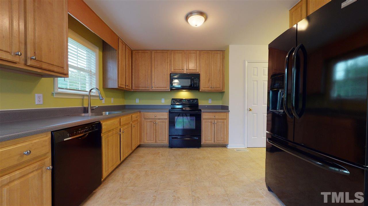 4840 Topstone Road Raleigh, NC 27603 - Photo 16 of 30 a kitchen with granite countertop a refrigerator and a stove top oven