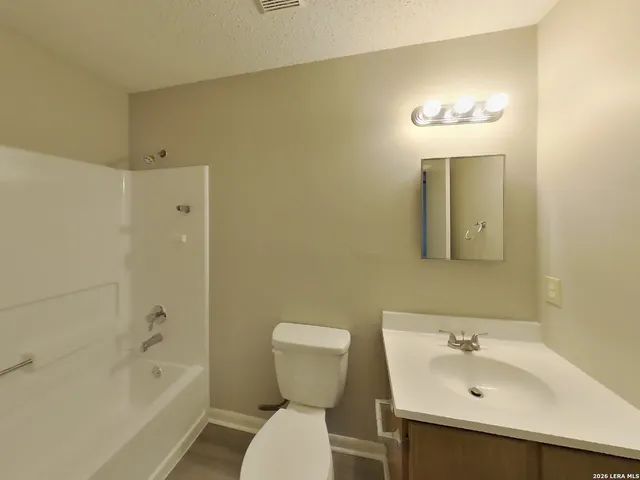 a bathroom with a sink mirror toilet and bathtub