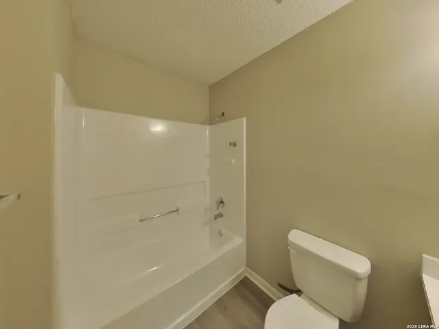 a white toilet sitting next to a bath tub