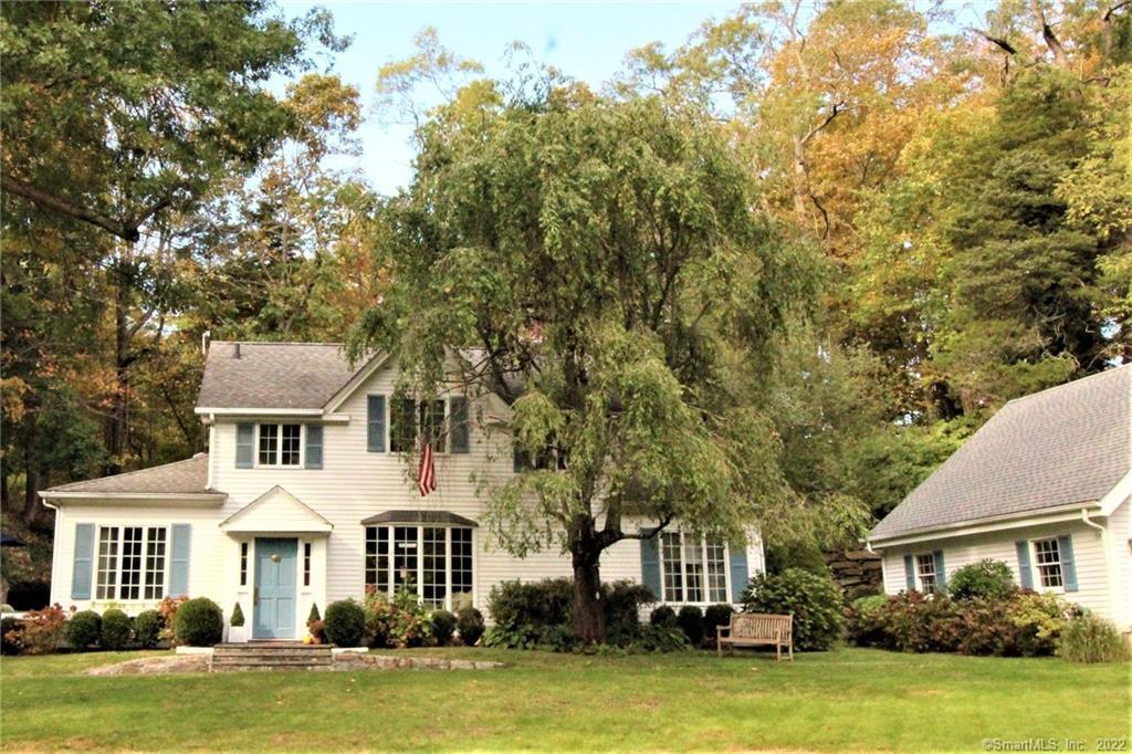 299 Riversville Road Greenwich, CT 06831 - Photo 1 of 1 a front view of a house with a garden and trees