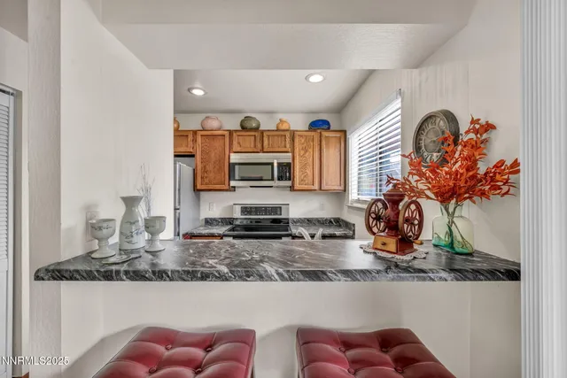 a kitchen with stainless steel appliances granite countertop a sink a stove a microwave a counter top and cabinets