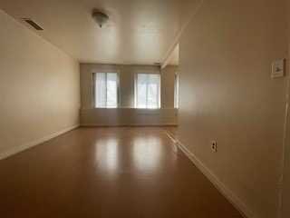 806 South Street Peekskill, NY 10566 - Photo 3 of 9 an empty room with wooden floor and windows