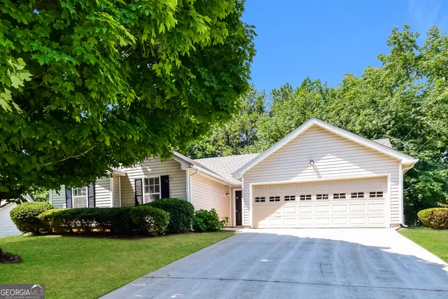 a view of house with garden and tall tress