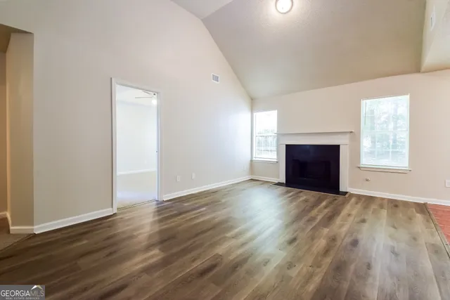 a view of empty room with wooden floor and fireplace