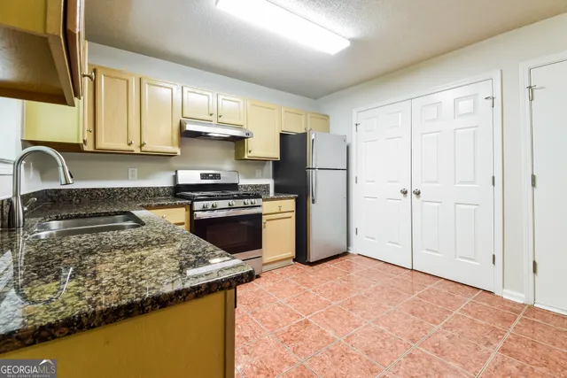 a kitchen with a refrigerator sink and stove