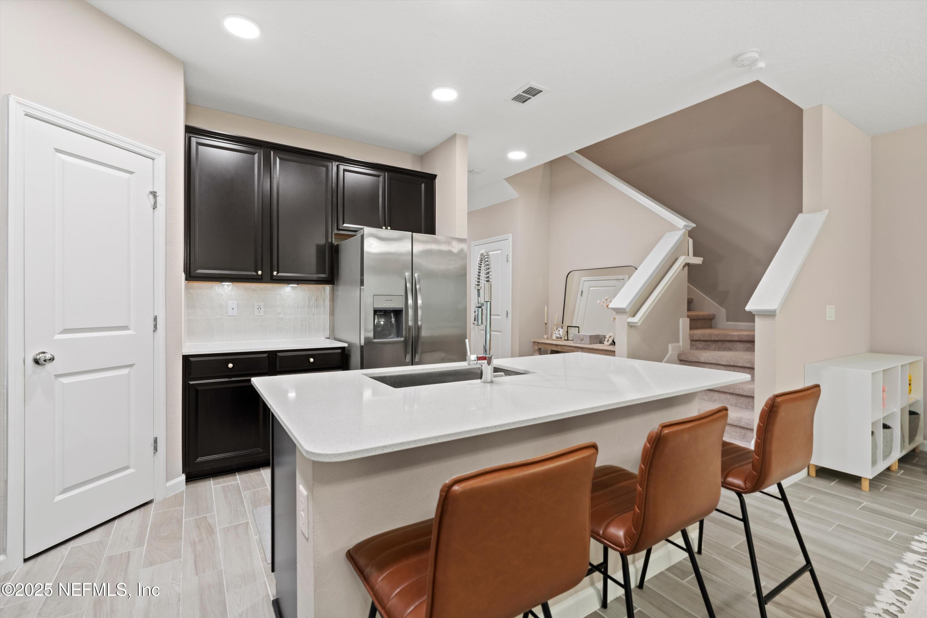 352 Boracay Circle St. Johns, FL 32259 - Photo 11 of 45 a kitchen with stainless steel appliances kitchen island a table chairs and refrigerator