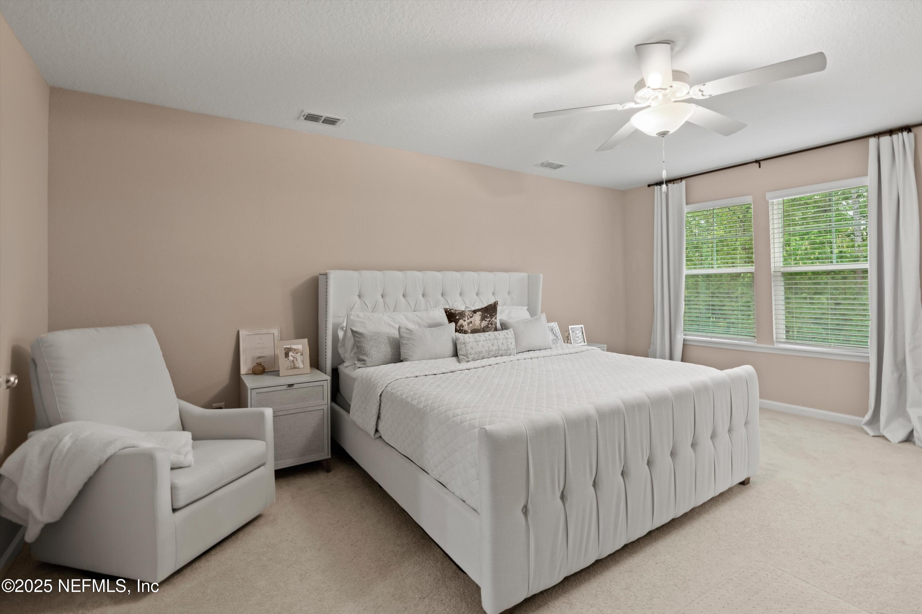 352 Boracay Circle St. Johns, FL 32259 - Photo 18 of 45 a bedroom with a white bed couch chandelier and a large window