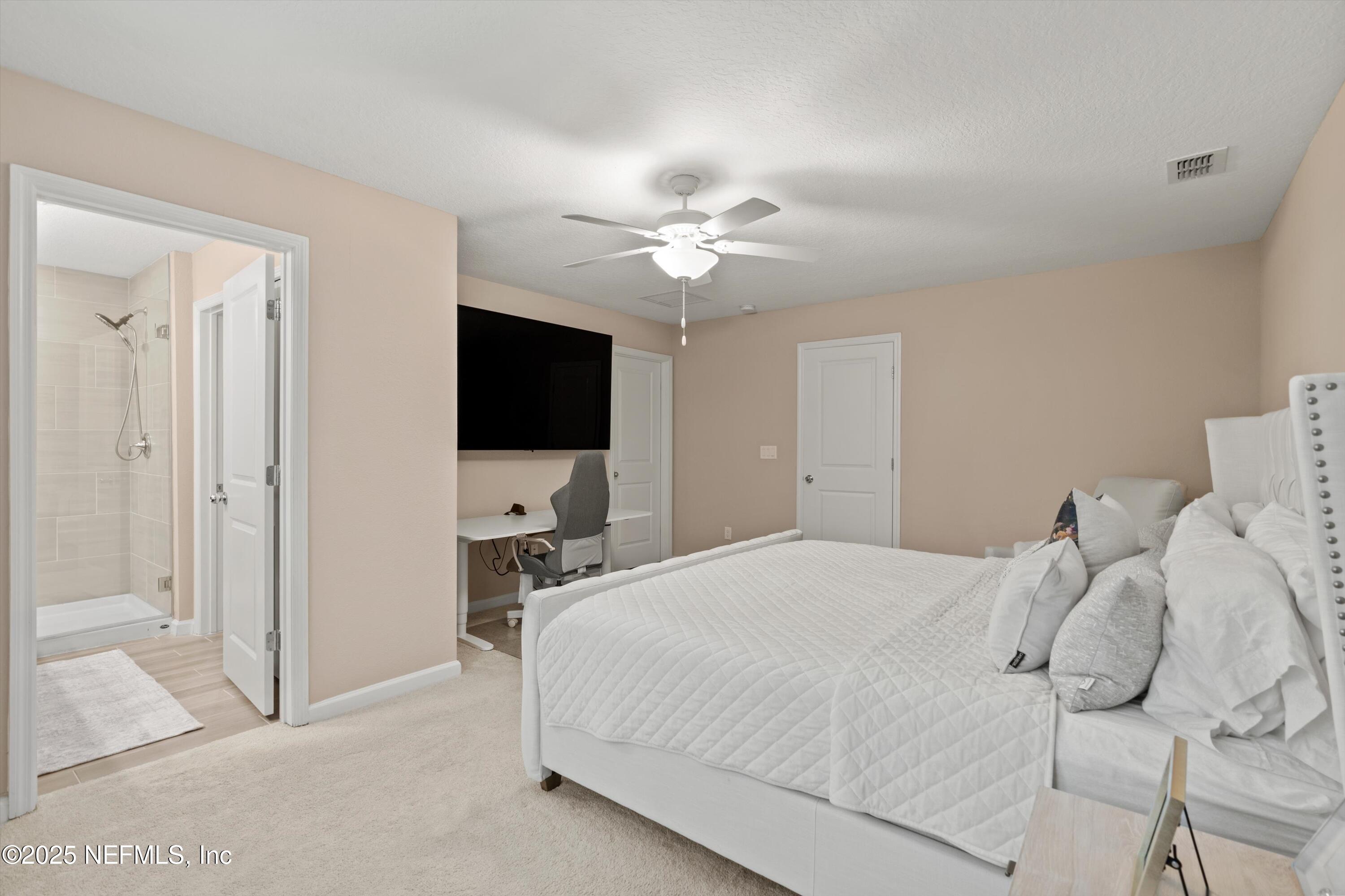 352 Boracay Circle St. Johns, FL 32259 - Photo 20 of 45 a bedroom with a bed tv and a chandelier