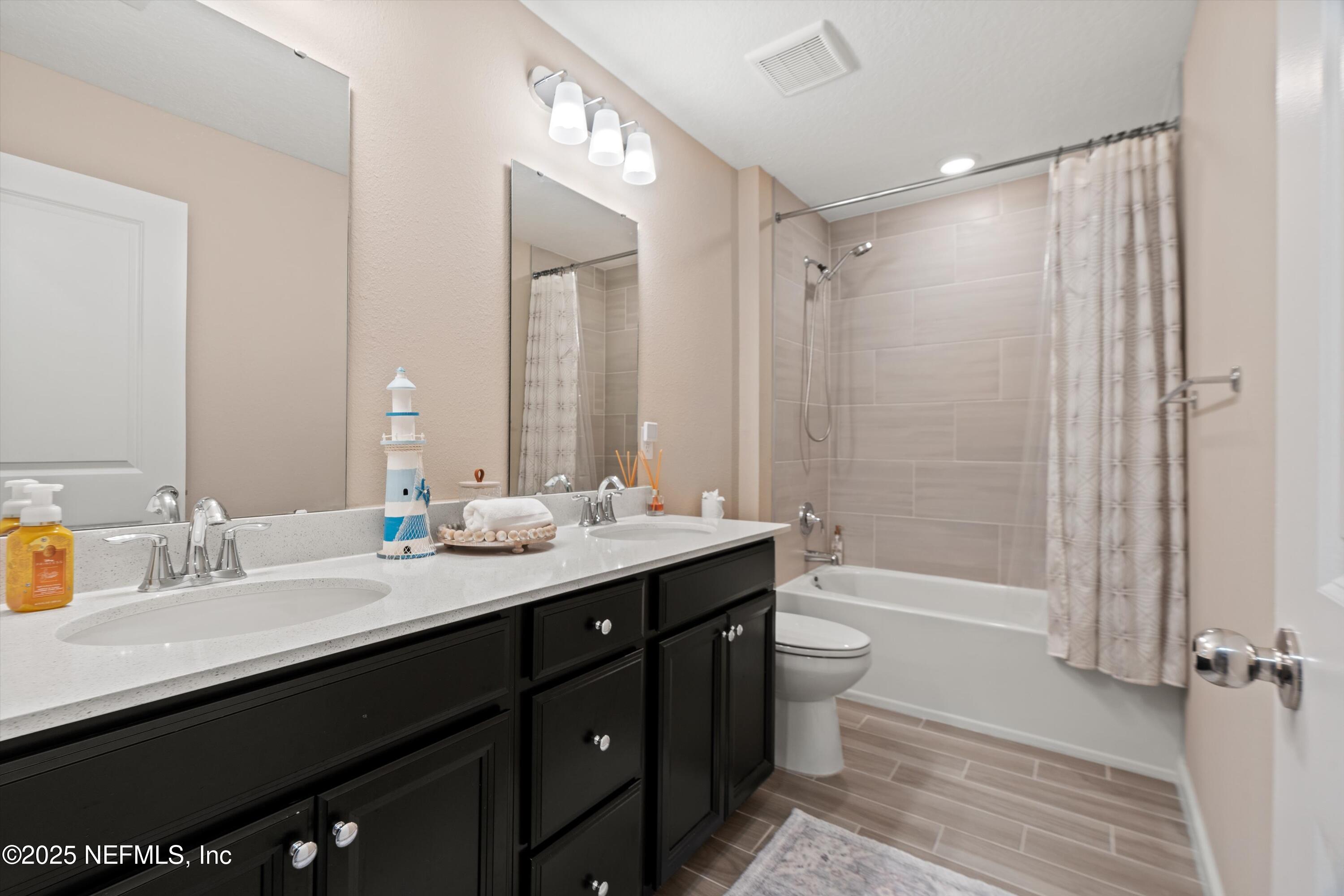 352 Boracay Circle St. Johns, FL 32259 - Photo 27 of 45 a bathroom with a double vanity sink toilet mirror and bathtub