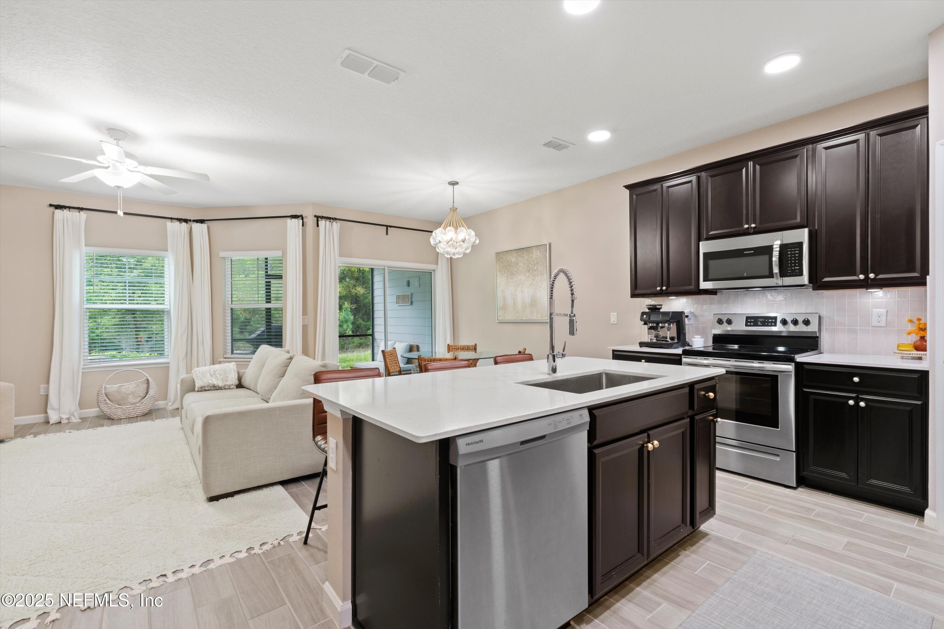 352 Boracay Circle St. Johns, FL 32259 - Photo 8 of 45 a kitchen with kitchen island granite countertop a sink stove and microwave