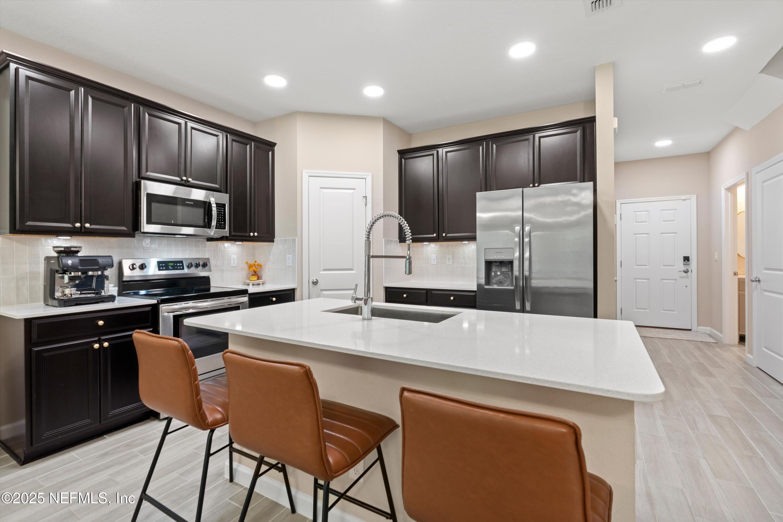 352 Boracay Circle St. Johns, FL 32259 - Photo 10 of 45 a kitchen with stainless steel appliances wooden cabinets a stove a sink and a refrigerator