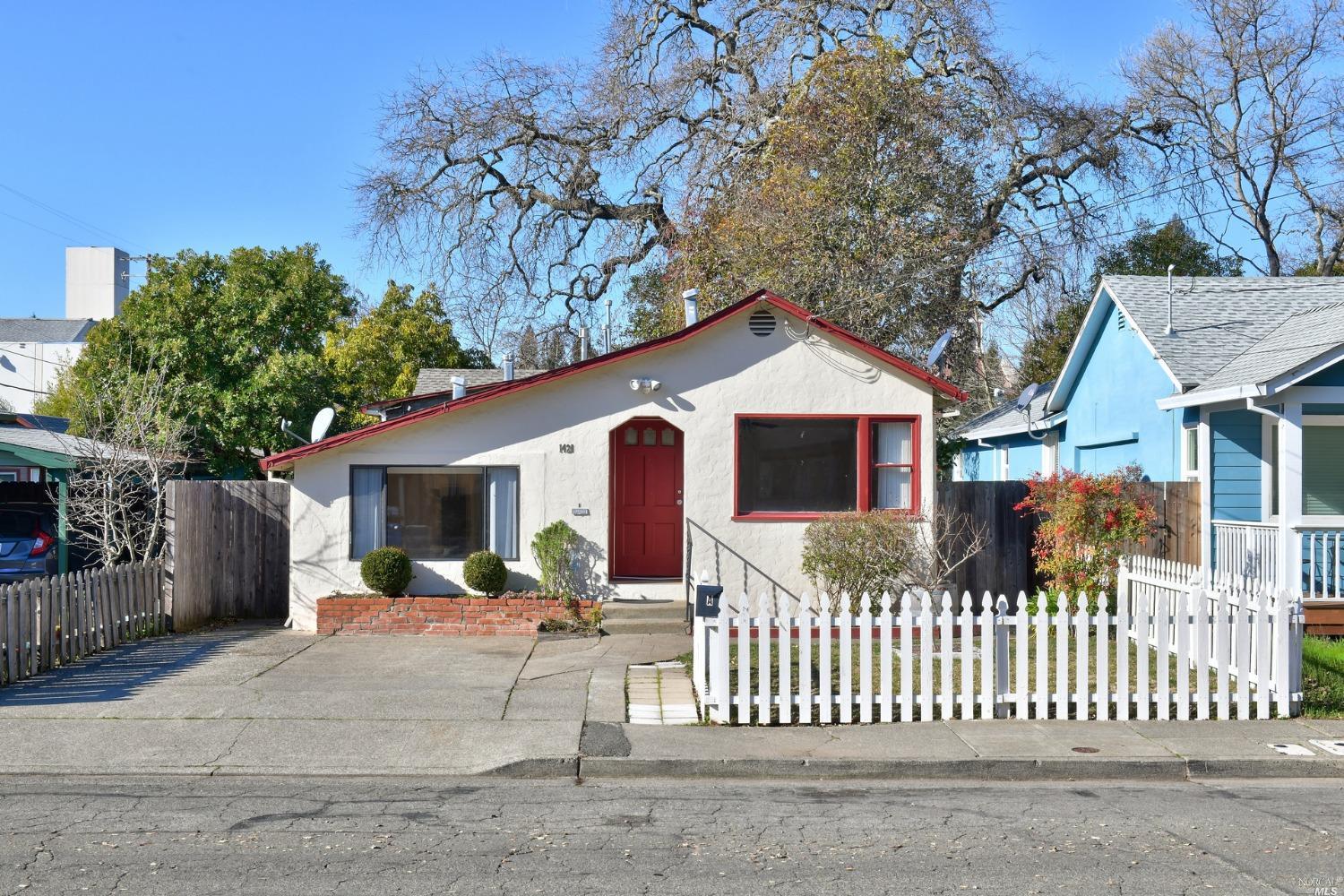 a front view of house yard with large trees