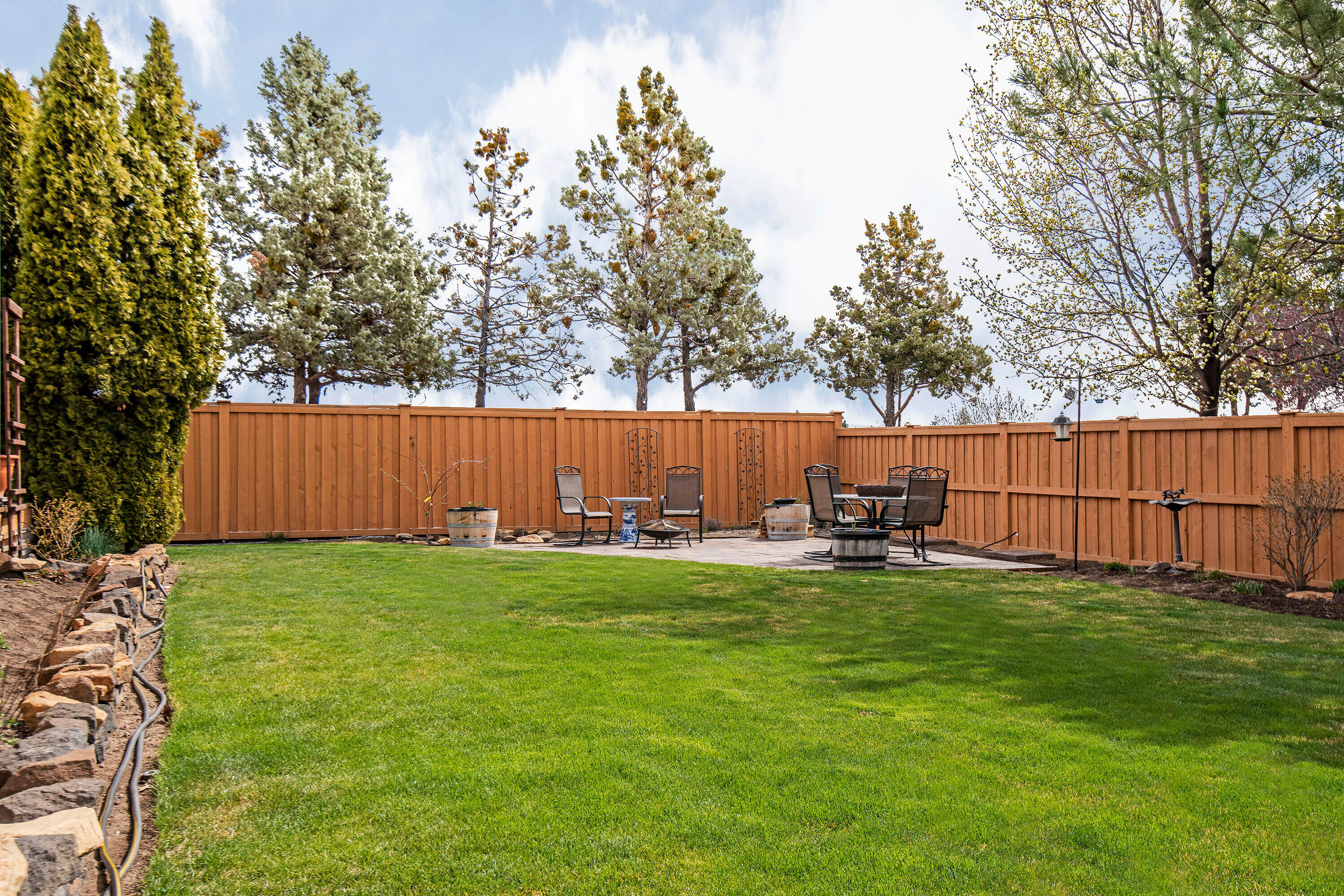 3357 Northeast Stonebrook Loop Bend, OR 97701 - Photo 18 of 26 a view of a backyard with table and chairs and wooden fence