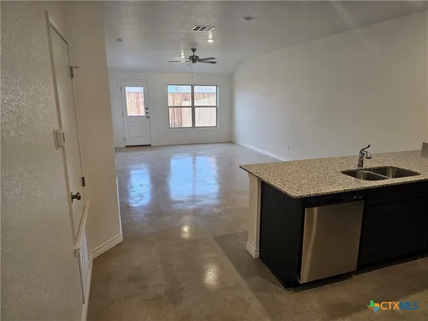 an empty room with windows and cabinet
