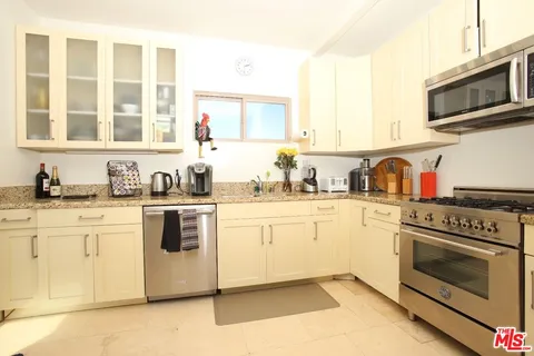 a kitchen with granite countertop cabinets stainless steel appliances and a sink