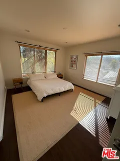 a living room with a bed and a large window