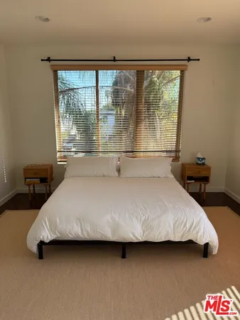 a bed sitting in a bedroom next to a window