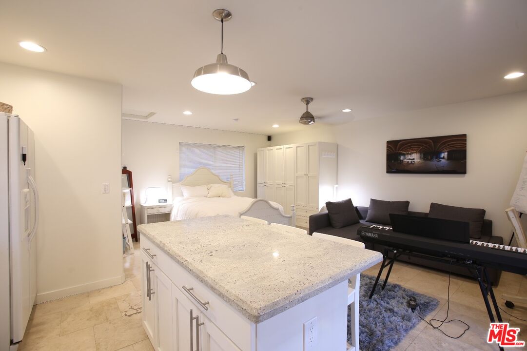 4447 Calhoun Avenue Sherman Oaks, CA 91423 - Photo 18 of 28 a large white kitchen with a stove a sink a refrigerator and a dining table with wooden floor