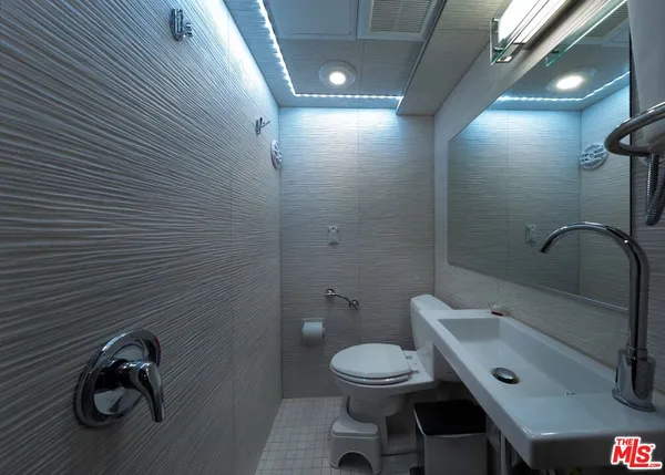 a bathroom with a toilet sink and mirror