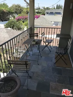 a view of a balcony with wooden floor and outdoor seating