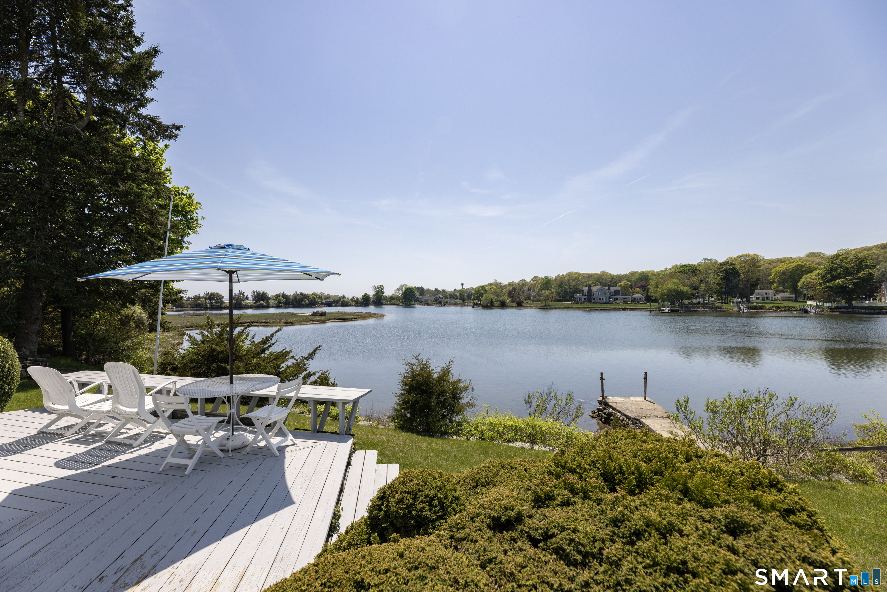 27 Wilbur Road Stonington, CT 06378 - Photo 20 of 40 a view of a lake with couches chair and umbrella