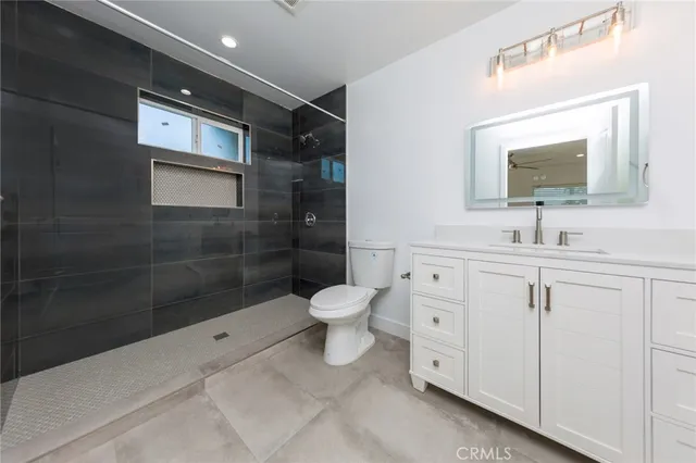 a bathroom with a toilet a sink a shower and a mirror