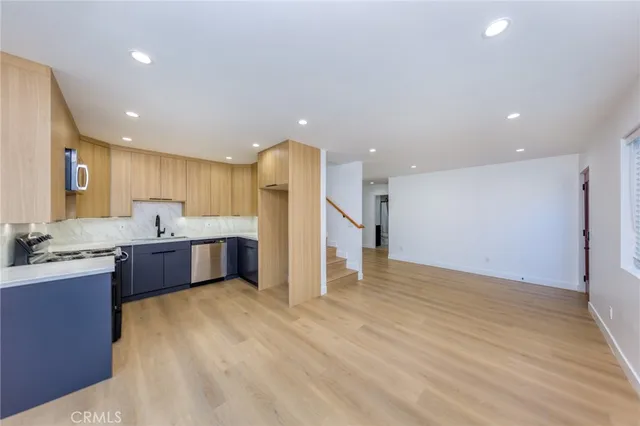 a large kitchen with stainless steel appliances kitchen island a large counter top a sink and a stove