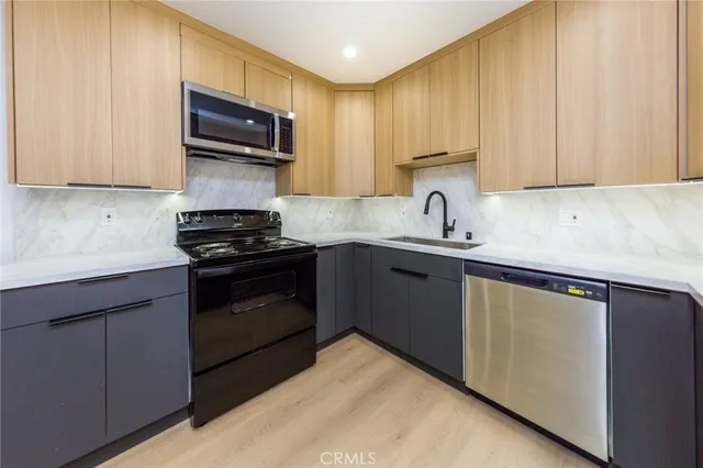 a kitchen with granite countertop cabinets stainless steel appliances and a sink