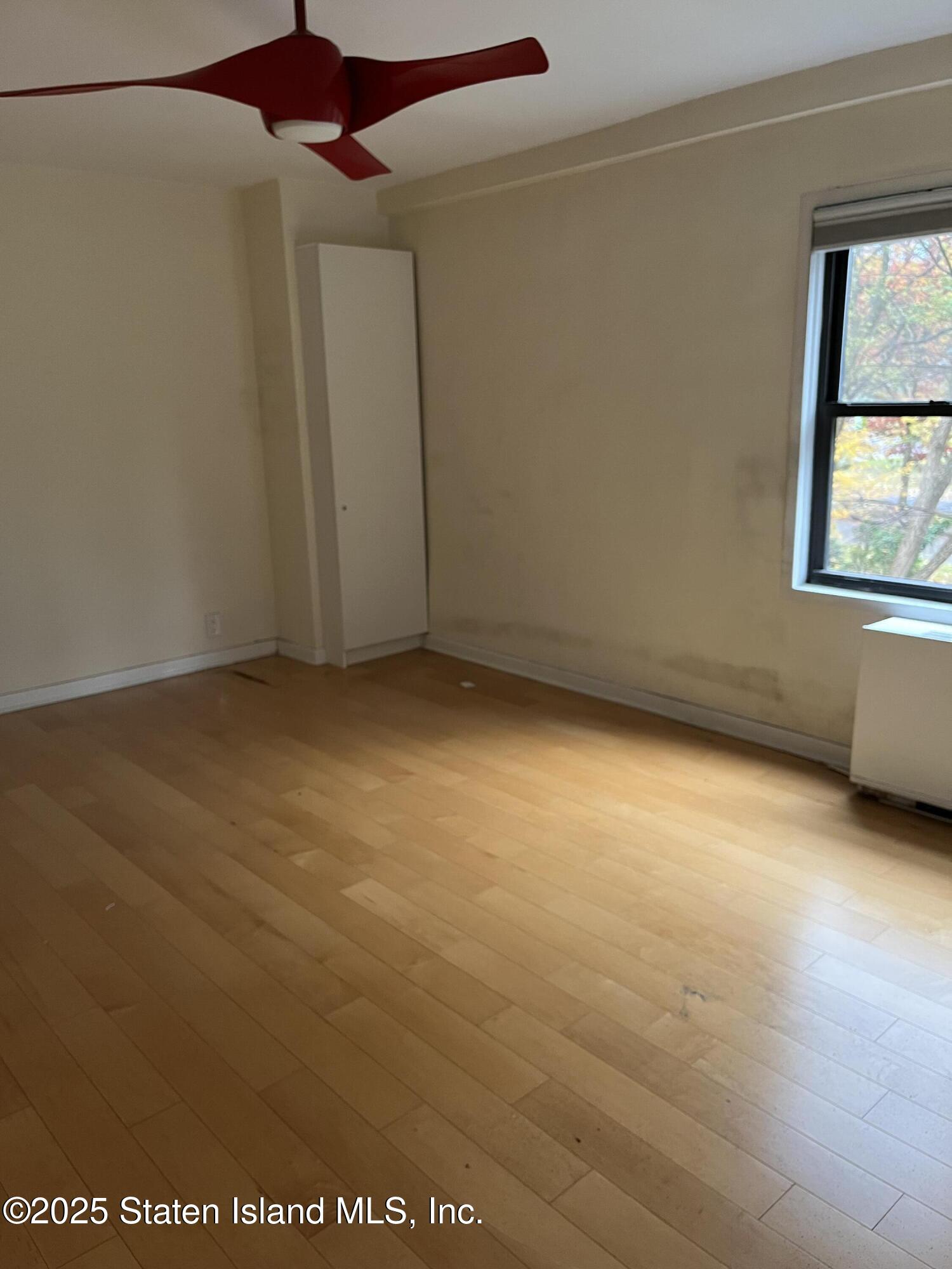 1100 Clove Road, Unit 2L Staten Island, NY 10301 - Photo 14 of 20 an empty room with a window and a ceiling fan