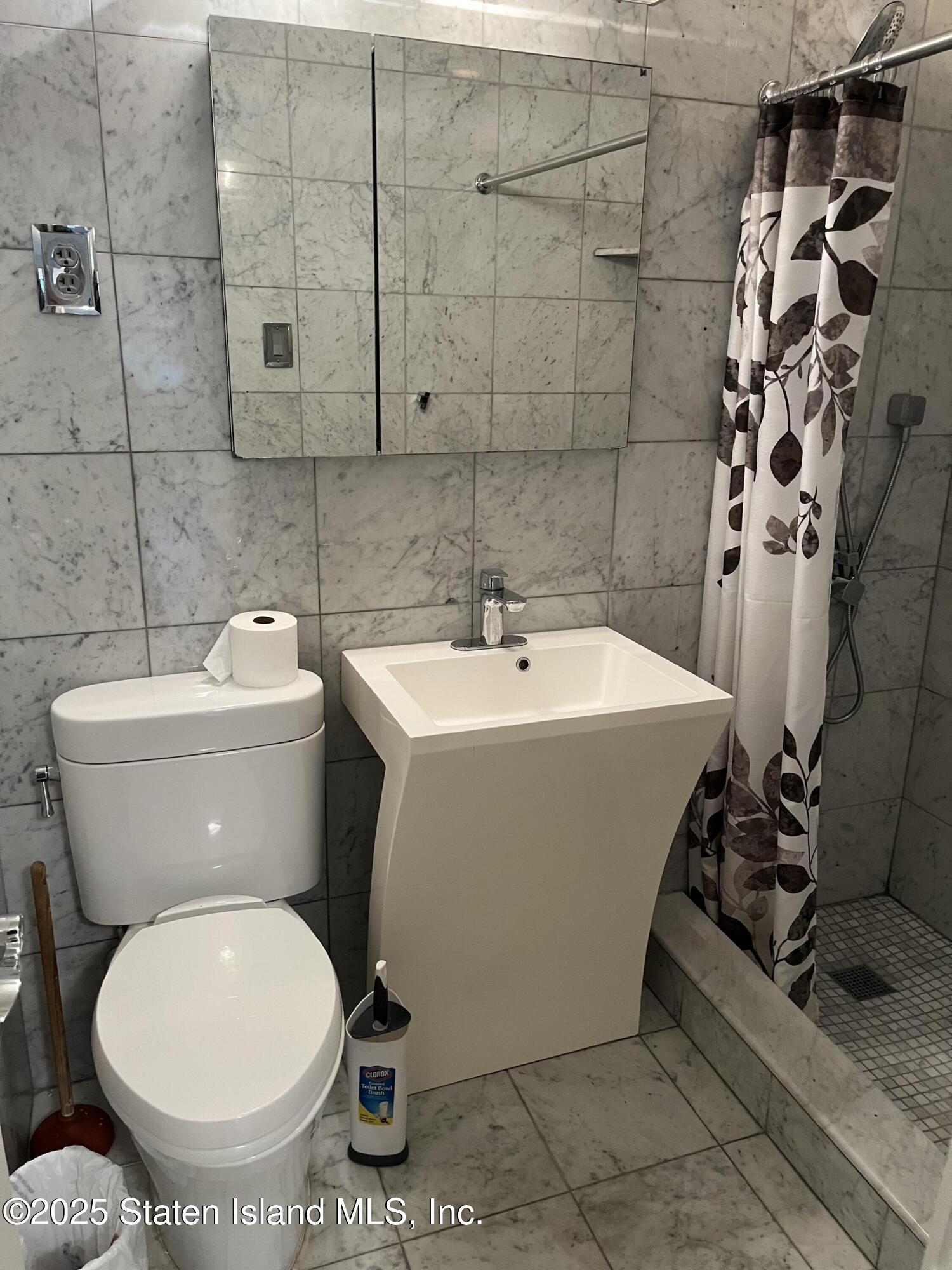 1100 Clove Road, Unit 2L Staten Island, NY 10301 - Photo 18 of 20 a white toilet sitting next to a bathroom sink