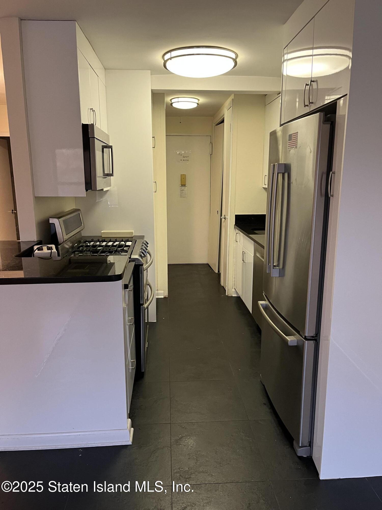 1100 Clove Road, Unit 2L Staten Island, NY 10301 - Photo 8 of 20 a kitchen with a refrigerator and a sink