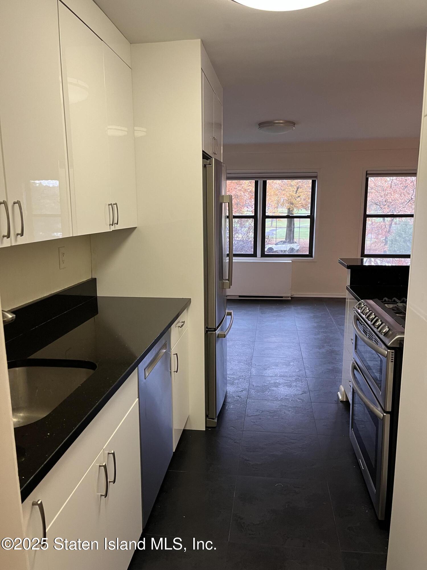 1100 Clove Road, Unit 2L Staten Island, NY 10301 - Photo 9 of 20 a kitchen with stainless steel appliances granite countertop a stove a sink and a microwave
